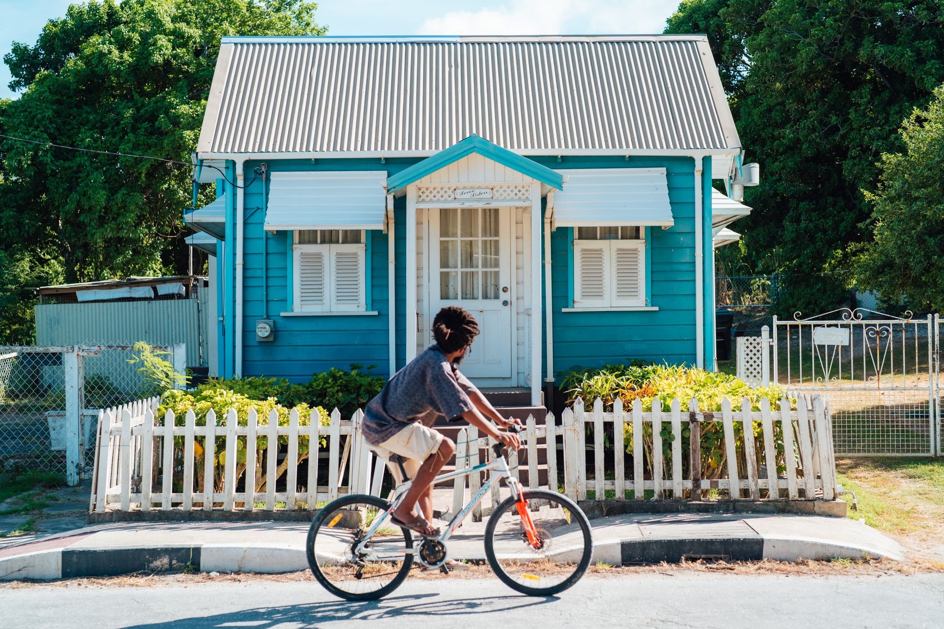 Barbados chattel house with man riding infant